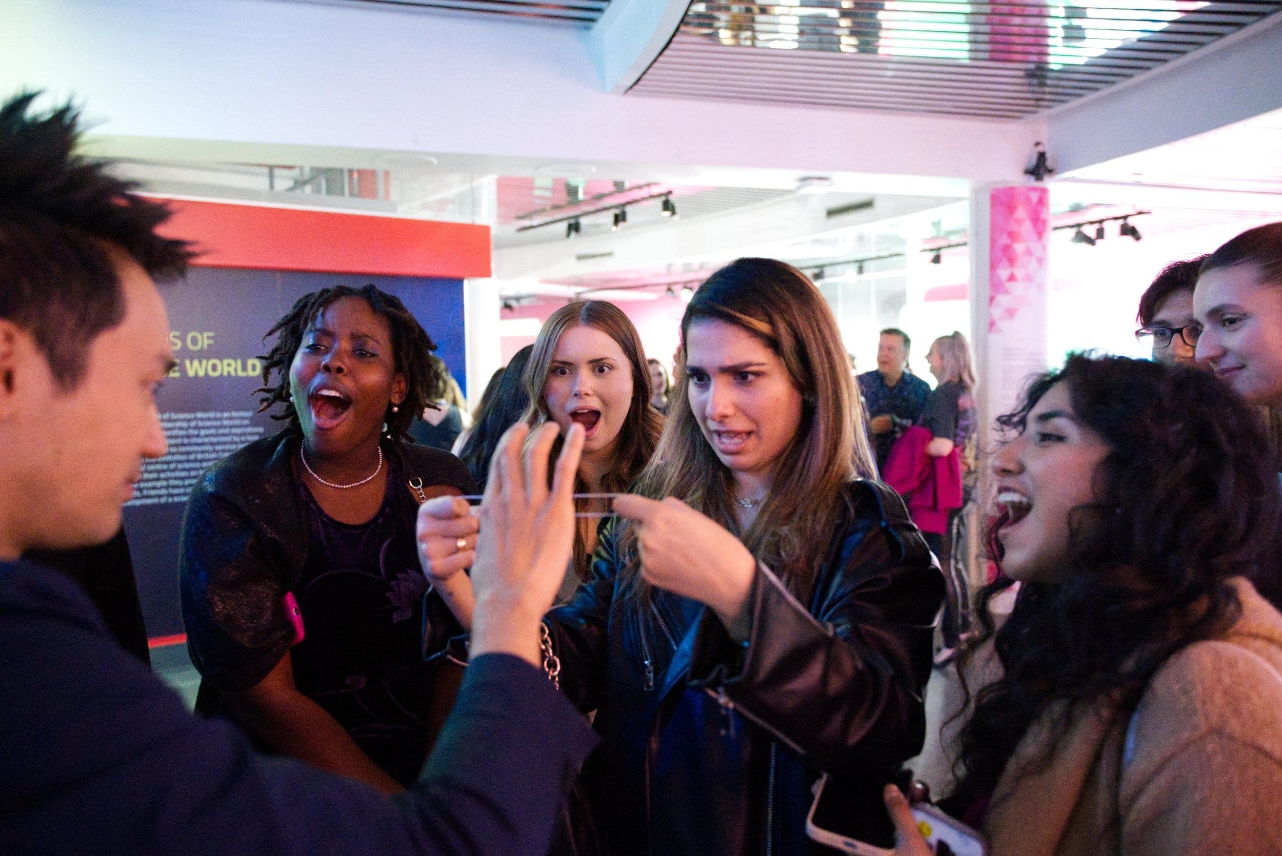 Guests reacting with open-mouthed amazement to close-up magic at a Vancouver event