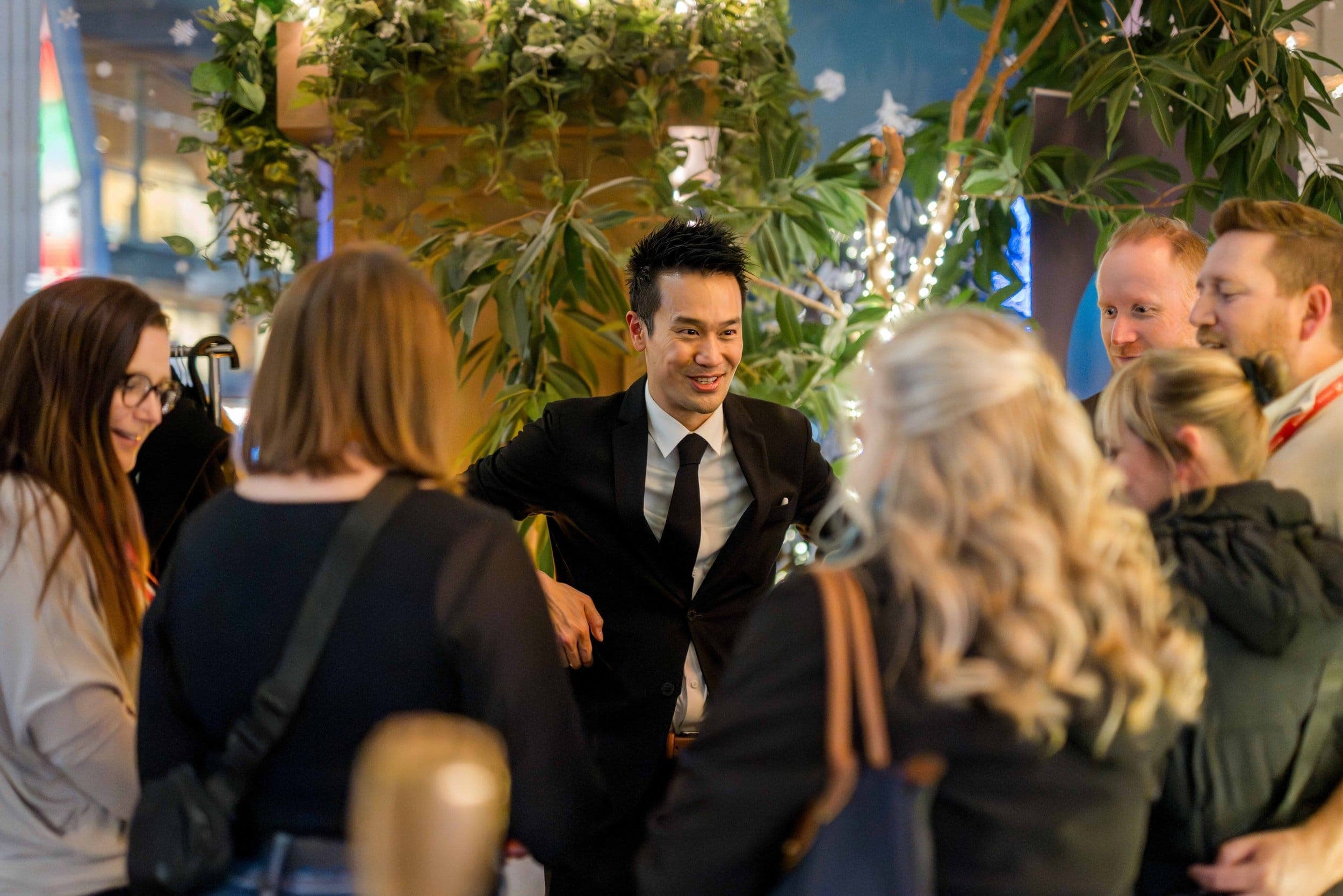 Kel laughing with guests during a standing reception at a Vancouver law firm event