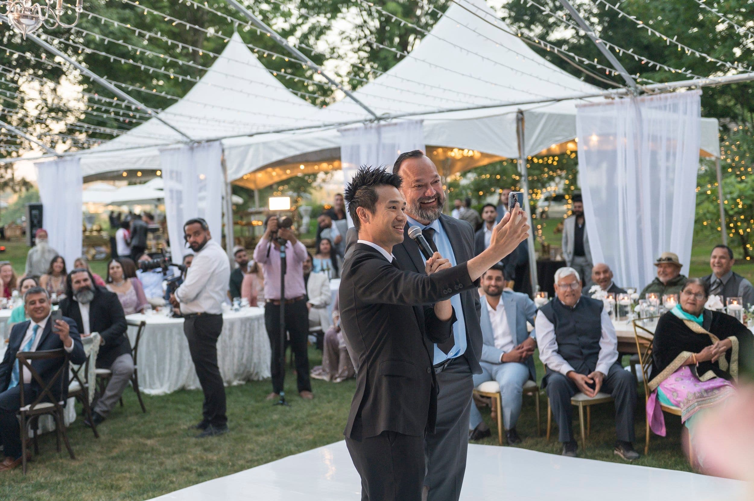 Guests applauding under a garden marquee at Neeraj and Natasha's Vancouver wedding