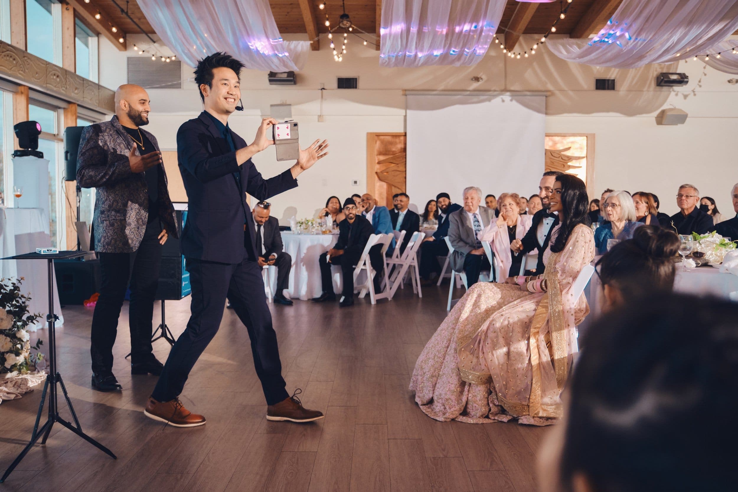 Kel performing with a second entertainer in front of seated guests at a Vancouver wedding
