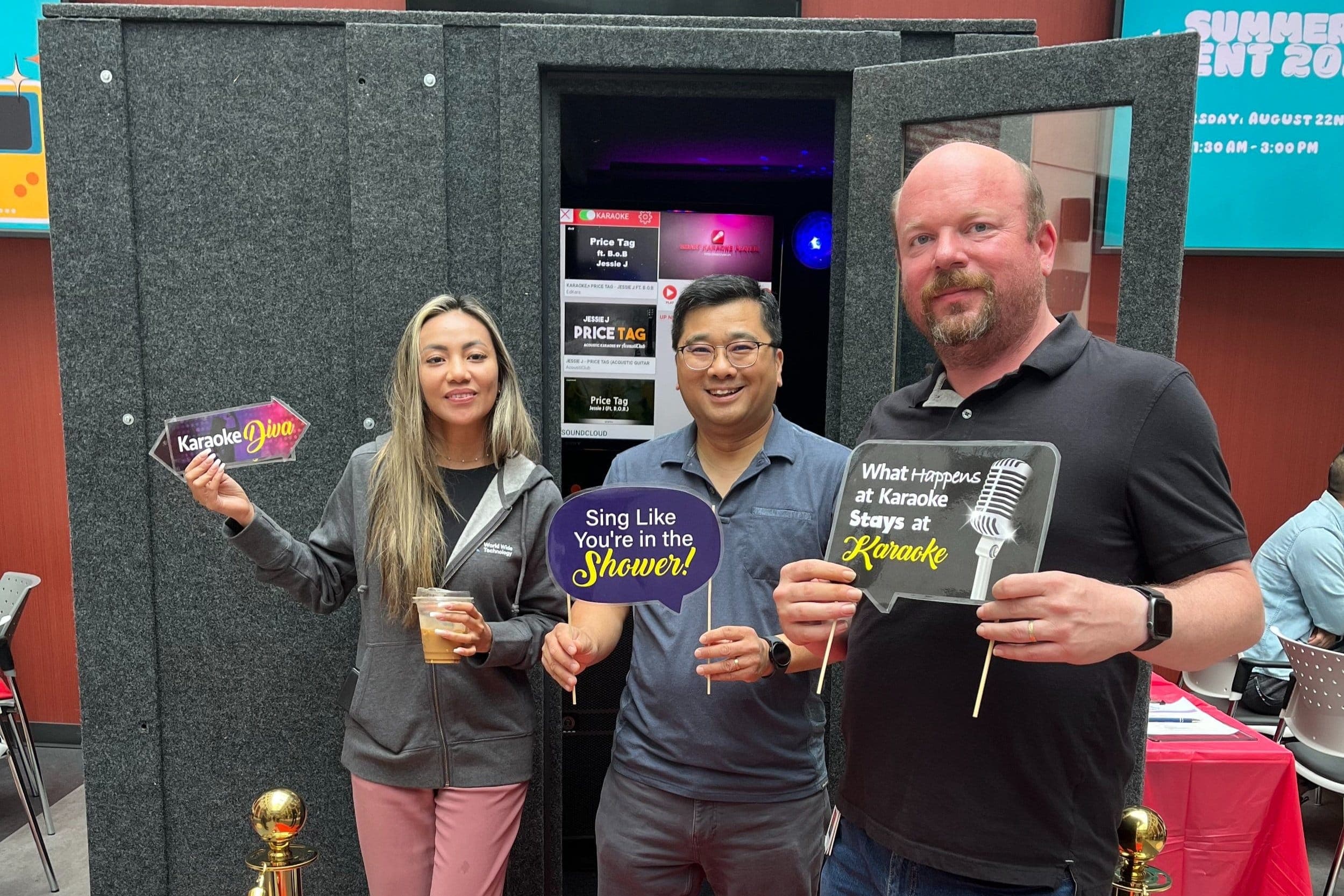 Guests holding karaoke props beside the Party Karaoke Box at a Vancouver tech company event
