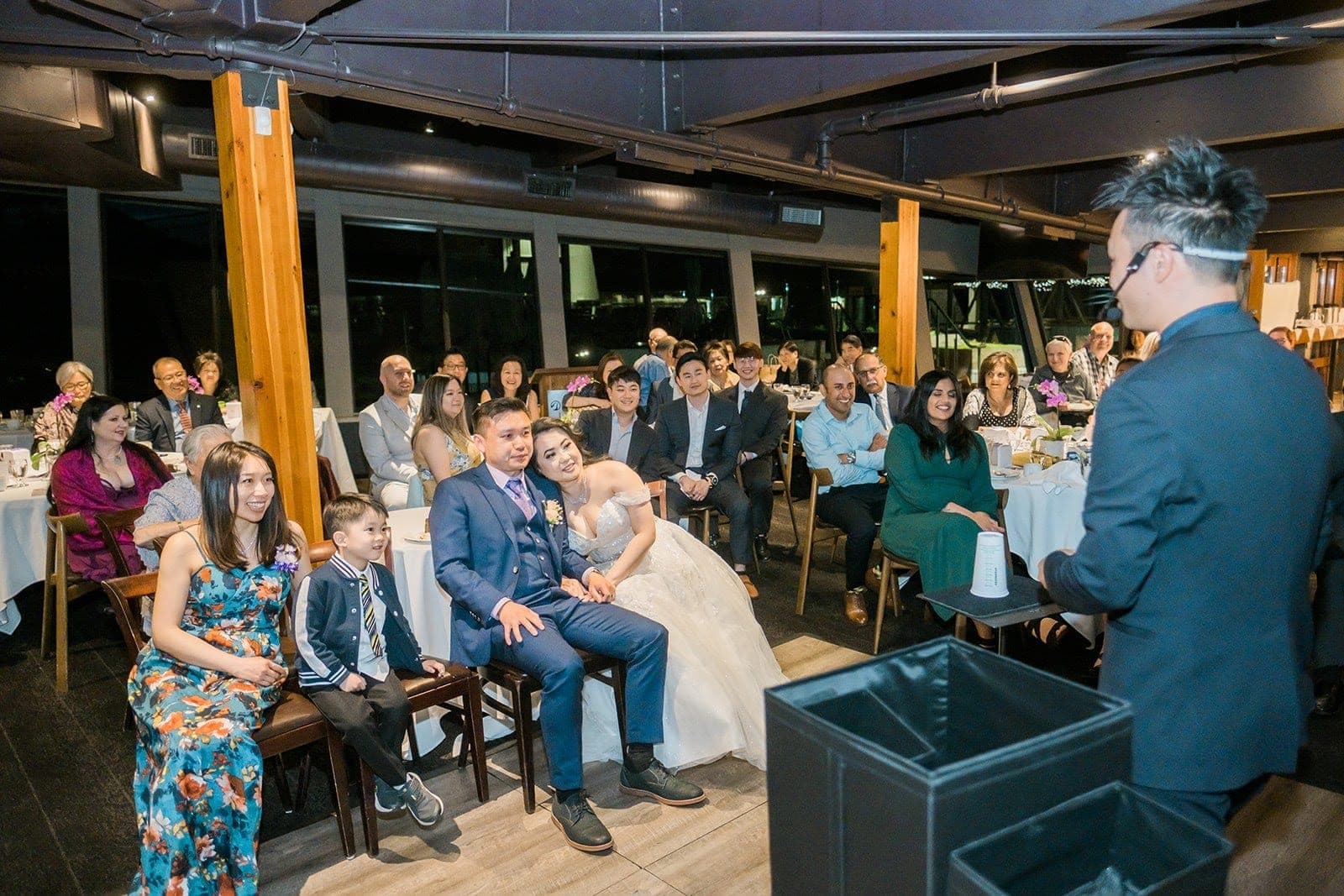 Kel speaking to a seated wedding party during a reception in a Vancouver restaurant