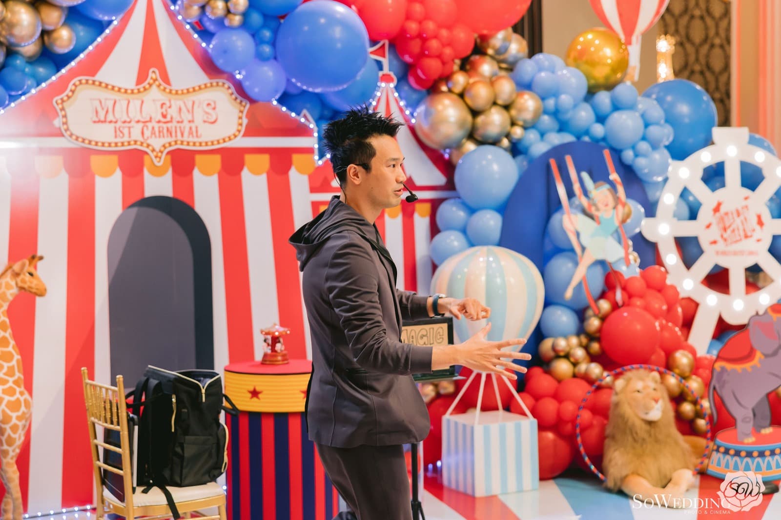 Kel presenting in front of a circus-themed balloon installation styled by Blooms and Paper in Vancouver