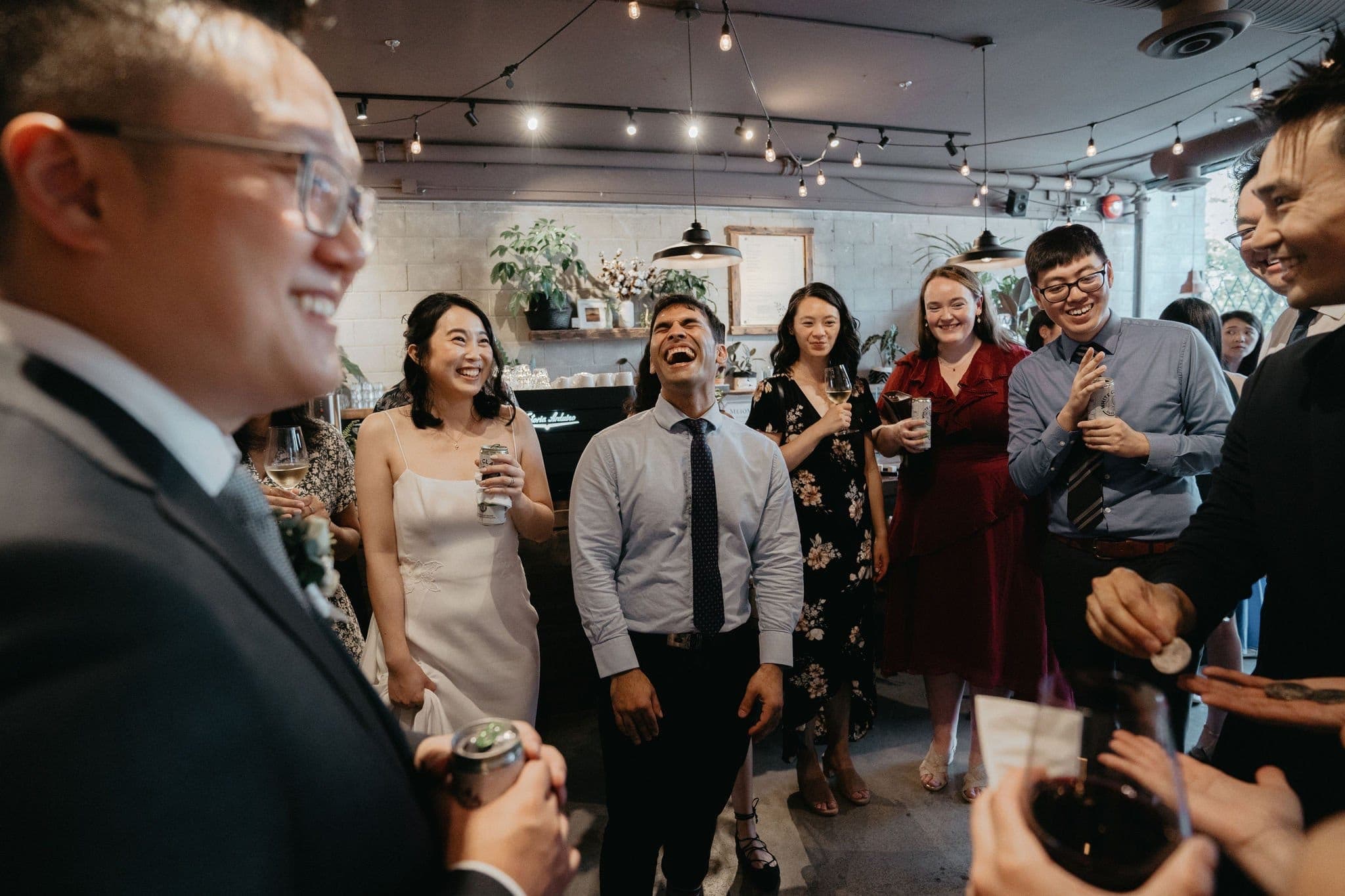 Wedding guests standing together laughing during a Vancouver reception