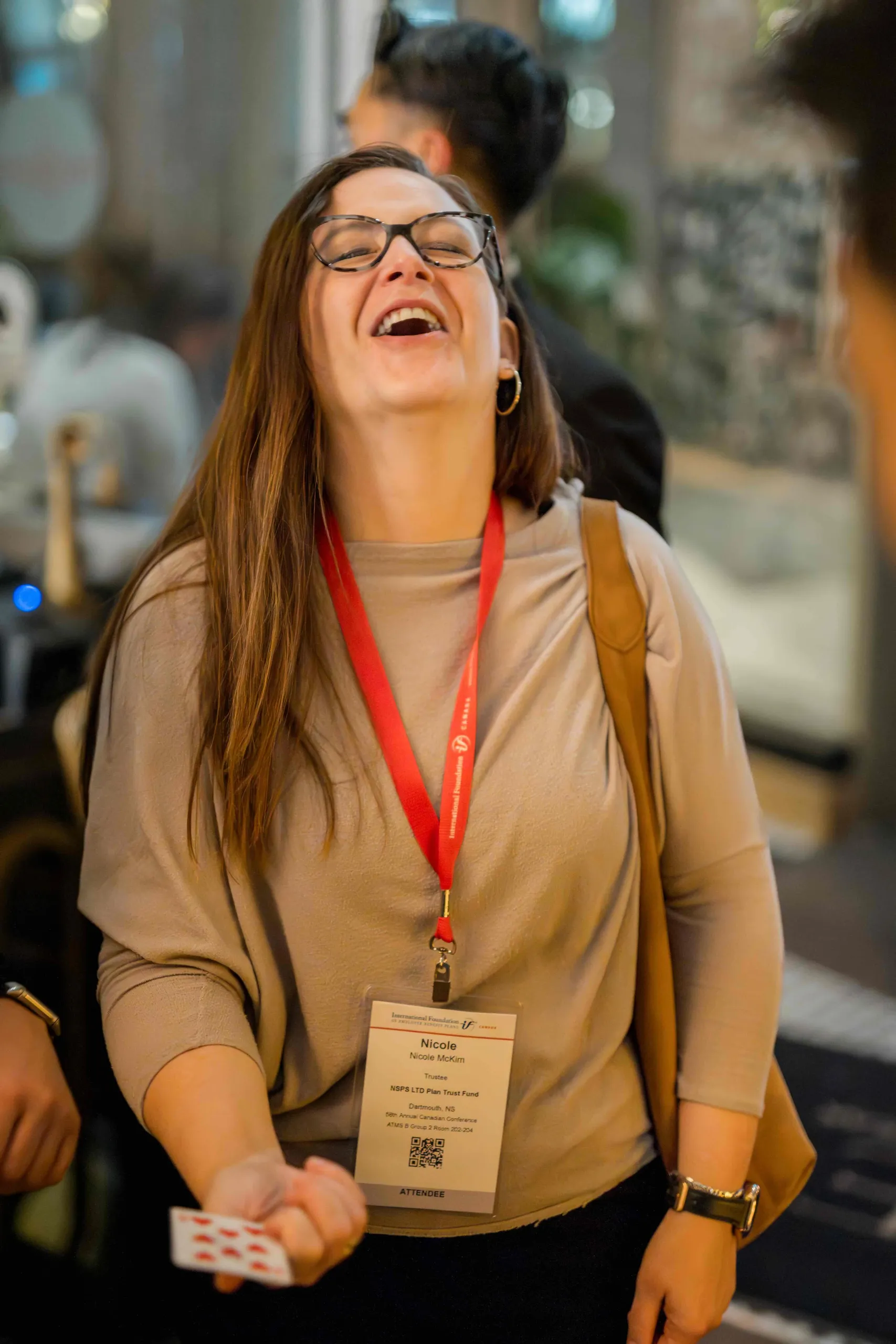 A guest reacting with disbelief during close-up magic at a company holiday party