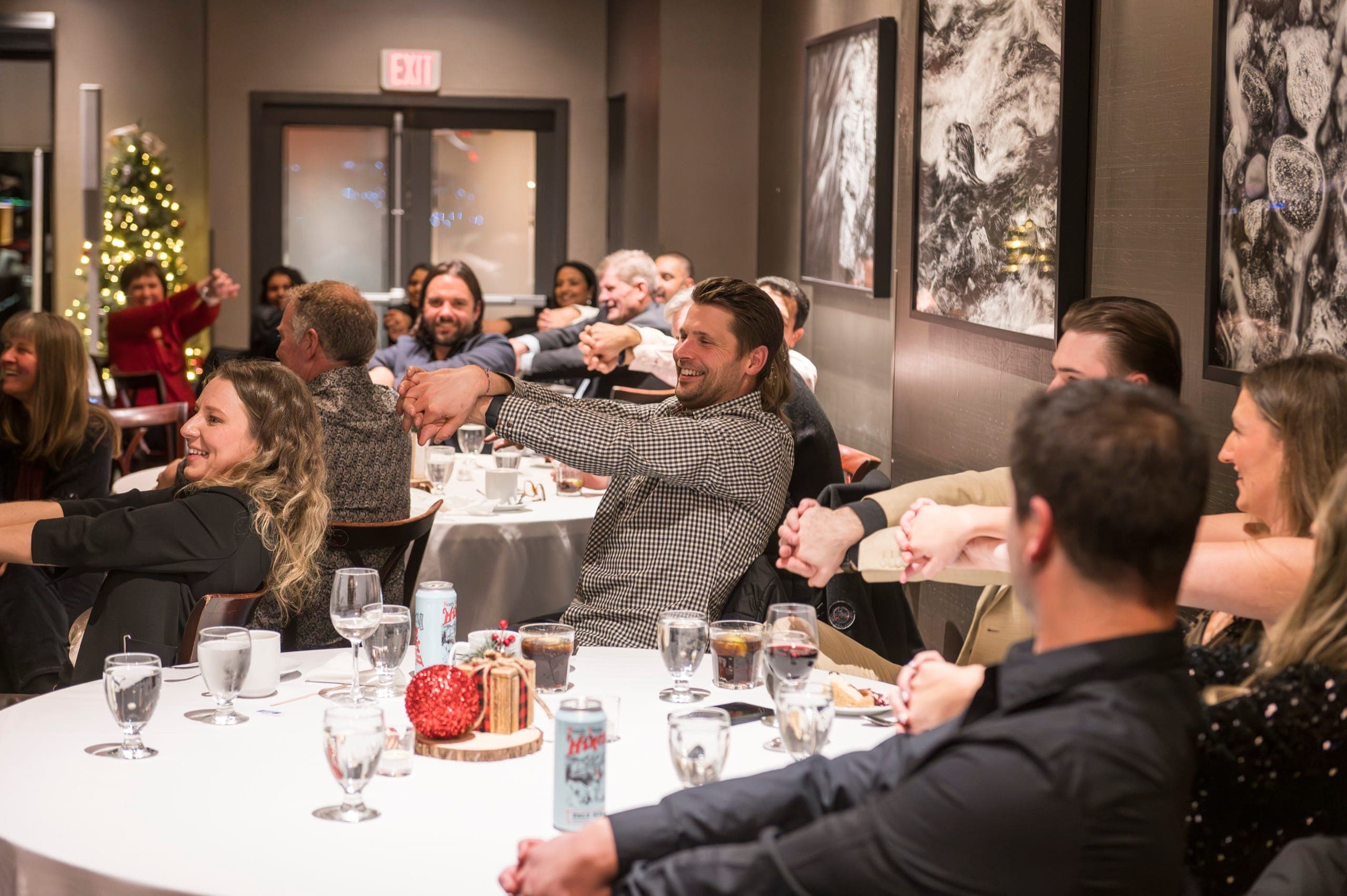 A full room of corporate guests with hands linked taking part together during a mentalism routine in Vancouver